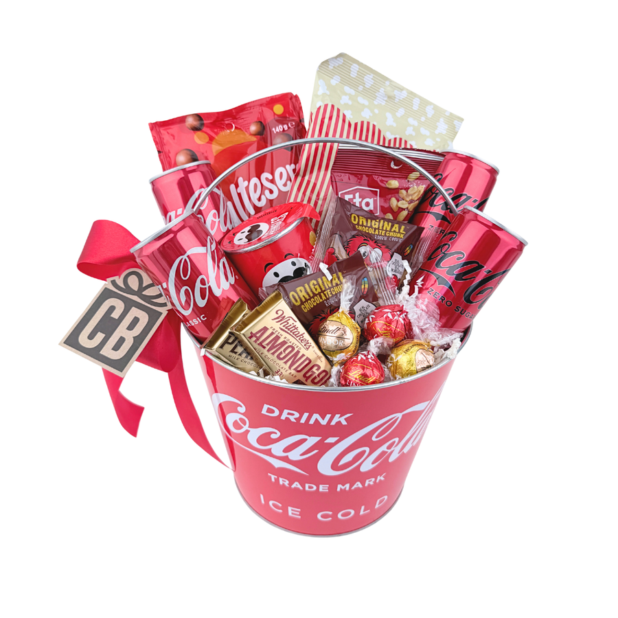 Coca-Cola themed gift basket with snacks and drinks on a white background
