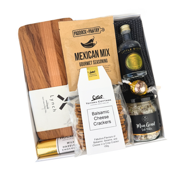 Gift set with wooden cutting board, snacks, and a bottle of wine on a white background